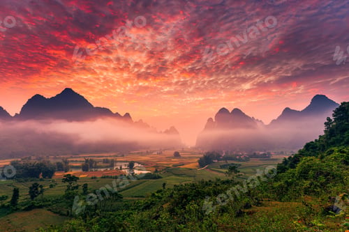 Preview: Sunrise over mountain range with foggy, river and traditional village in Phong Nam Valley