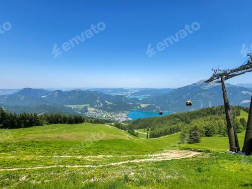 Preview: Ropeway over the green field against the background of the mountains