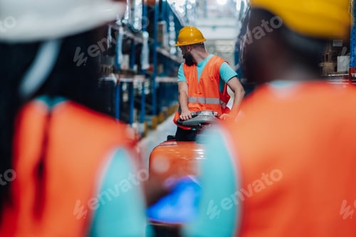 Preview: Warehouse worker driving forklift following colleagues in logistics center