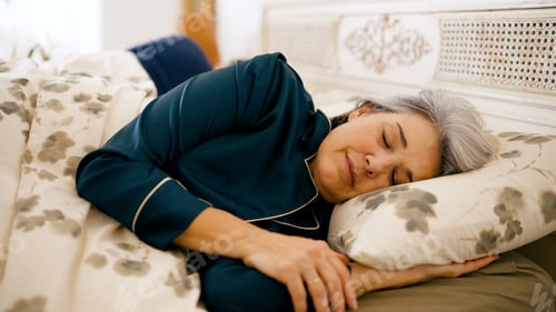 Preview: Senior woman peacefully sleeping in pajamas