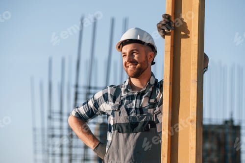 Preview: Standing and posing. Man is working on the construction site at daytime