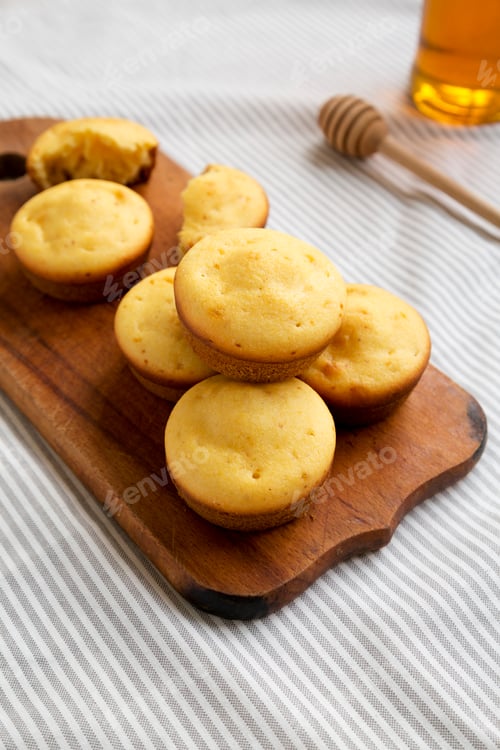 Preview: Homemade Cornbread Muffins on a rustic wooden board, side view.