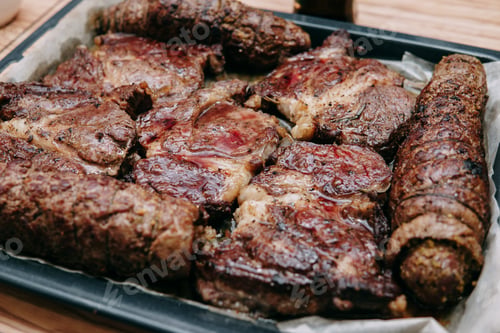 Preview: Cooking ribeye steaks and meat rolls in the cooking class. Cooked meat on protwin from the oven.