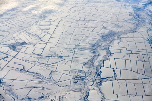 Preview: Aerial cloudscape view over clouds top to snow covered rivers, roads, cities and fields, winter air