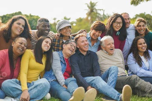 Preview: Crowd of happy multiracial people hugging each other outdoor while smiling in front of camera