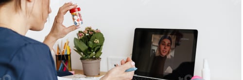 Preview: Woman doctor showing medicine while making video call on laptop