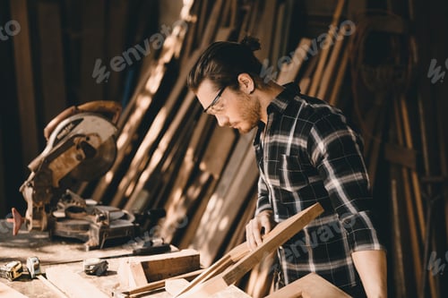 Preview: Carpenter young man hand made crafting furniture in DIY wood workshop. Caucasian authentic real wood