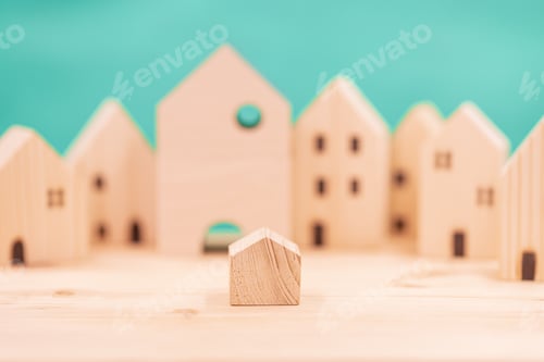 Preview: Small house in the big city concept. little model wooden home in the wood village.