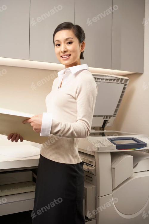Preview: Young Woman Standing Next To Photocopier