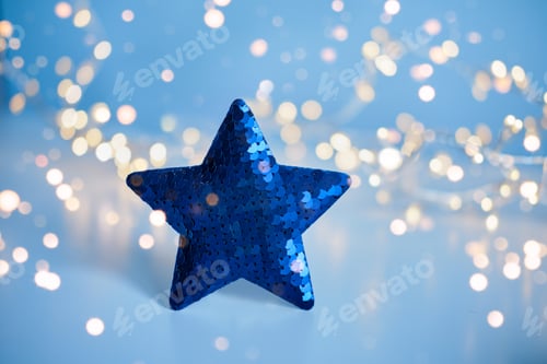 Preview: Blue sequins Christmas star with blurred gold lights background, copy space