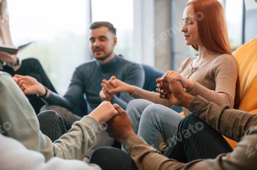 Preview: Sitting and holding each other by hands. Group of people are having therapy meeting together