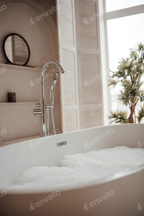 Preview: Luxury interior of big bathroom at modern african style with oval bathtub in natural lighting