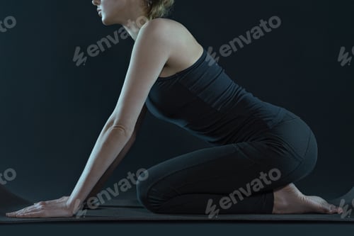 Preview: Young woman practicing yoga positions . sport workout fitness exercise. yoga mat black background.