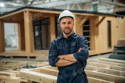 Preview: In white helmet. Male builder is at construction of wooden house