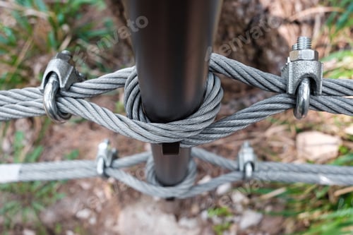 Preview: Interlocking steel cable secures a barrier on a mountain path.