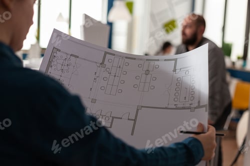 Preview: Architects looking at plans of blueprints for design