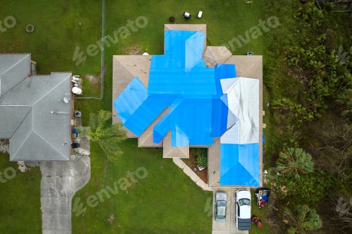Preview: Hurricane Ian damaged house rooftop covered with protective plastic tarp against rain water