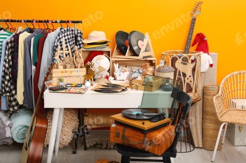 Preview: Many different stuff near orange wall indoors. Garage sale