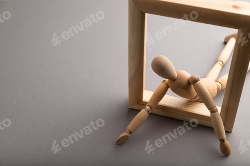 Preview: Wooden mannequin crawl out of a wooden frame on gray pastel background. escape, break rules