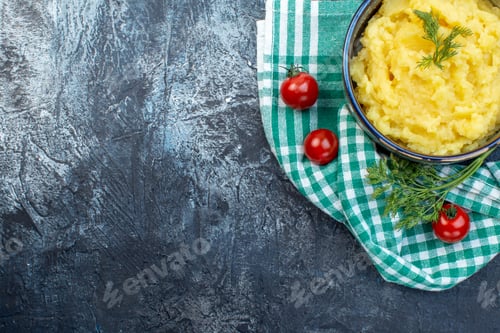 Preview: Half shot of mashed potatoes served with dill fresh tomatoes on green stripped towel on dark color