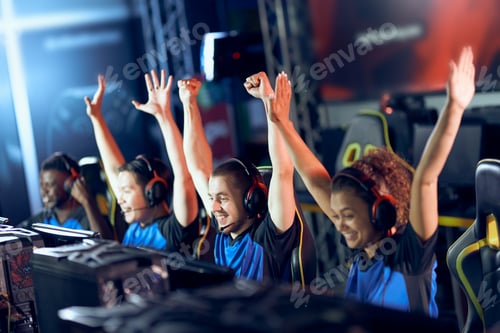 Preview: Team of happy professional cyber sport gamers celebrating success while participating in eSports