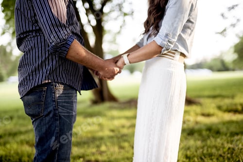 Preview: Closeup shot of a couple holding hands with a blurred background
