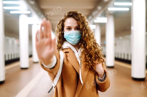 Preview: Healthy woman in blue medical protective mask showing gesture stop. A hand, a Stop sign.