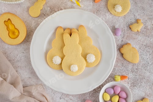 Preview: Easter Bunnies cookies on a white plate on a concrete background. Easter food background. Top view