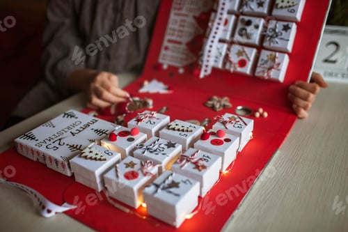 Preview: Pretty girl holds original advent calendar made of jewelry boxes and binder, Christmas diy craft
