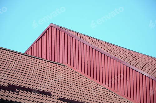 Preview: A fragment of a roof from a metal tile of dark red color. Quality Roofing