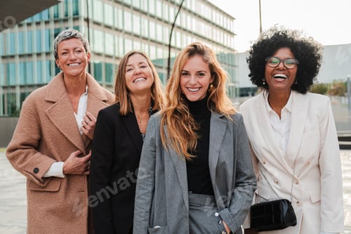 Preview: Group of proud businesswomen smiling and looking at camera at workplace. Real executive women