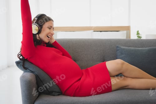 Preview: Pregnant woman lay down on couch and listening to the music for relaxing.