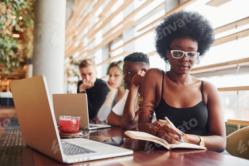 Preview: Black woman sitting in front of group of multi ethnic people