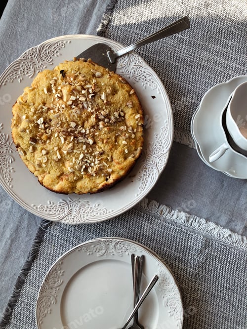 Preview: Pie decorated with nuts, cups on table.