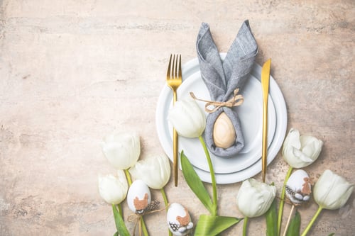 Preview: Easter holiday table setting with bunny from egg on white plate flowers.Happy Easter background
