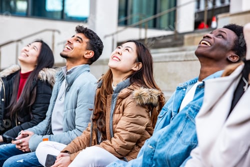 Preview: Diverse students looking up smiling outdoors with hope