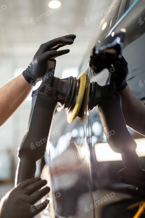 Preview: Professional man polishing a car in a garage