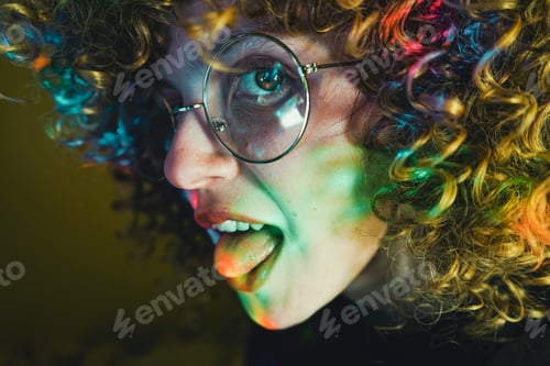 Preview: Young woman portrait illuminated by psychedelic lights