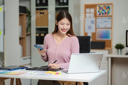 Preview: Female coder or developer working using a computer display and smartphone