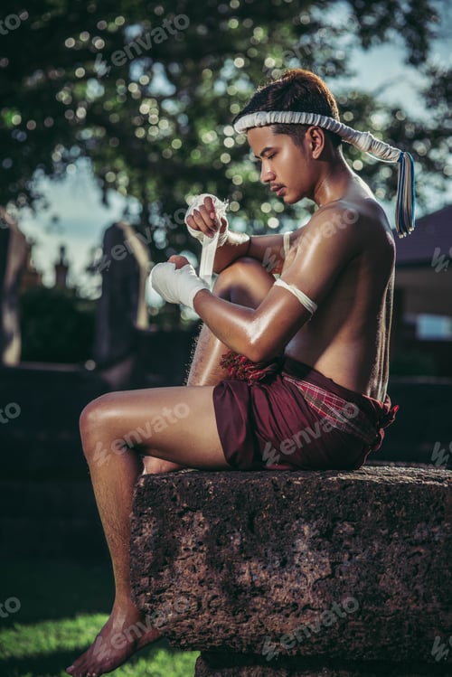 Preview: The boxer sat on the stone, tied the tape around his hand, preparing to fight.