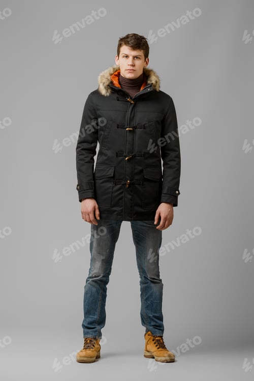 Preview: Full length portrait of handsome man in warm coat posing in studio