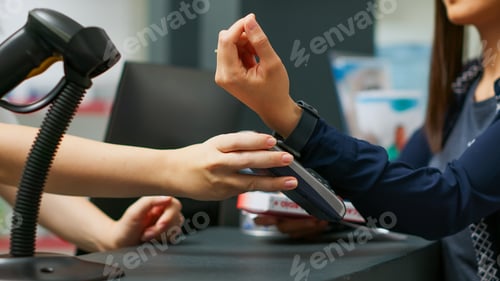Preview: Young adult buying healthcare medication and paying with smartwatch