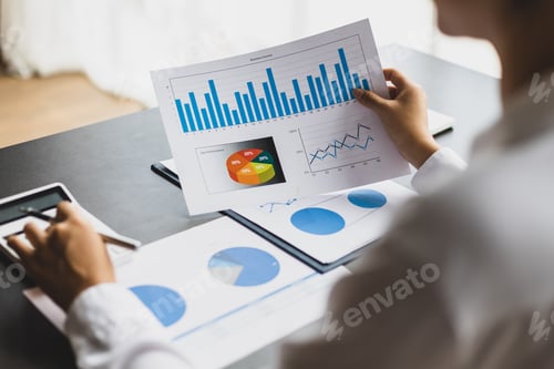 Preview: Businesswoman working on documents analyzing business finance charts and planning investments.