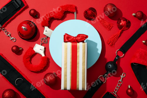 Preview: Sex toy with New Year's decor on a red background.