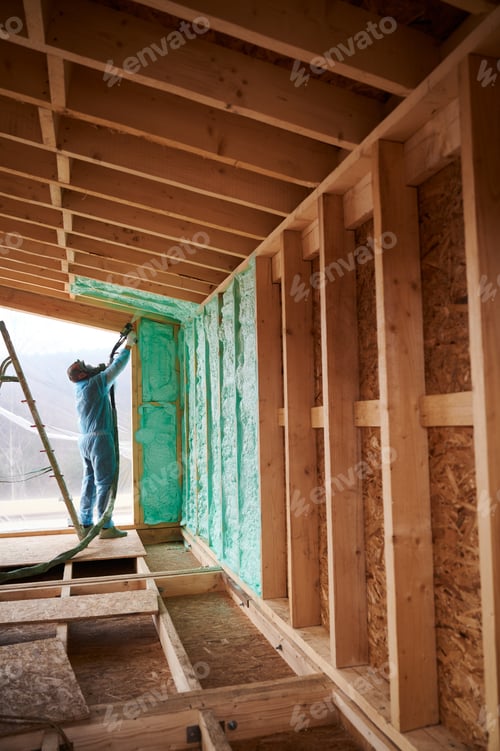Preview: Worker spraying polyurethane foam for insulating wooden frame house.