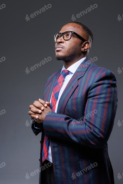 Preview: Successful African Businessman in Stylish Glasses and Suit with Hands Together, Leadership Portrait