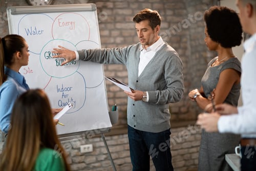 Preview: Male business leader presenting his colleagues new strategy on whiteboard.