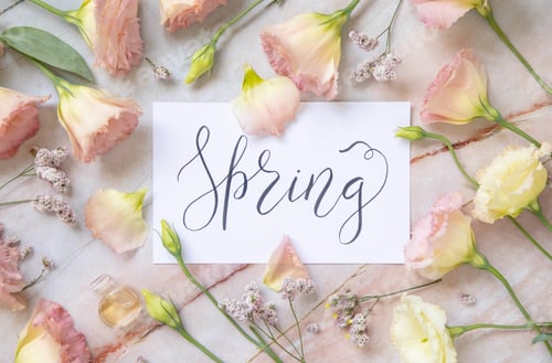 Preview: Card with the text SPRING near by pink flowers, earrings, petals and parfume flacon top view