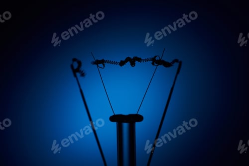 Preview: Electric bulb lamp with a burnt spiral on a blue background