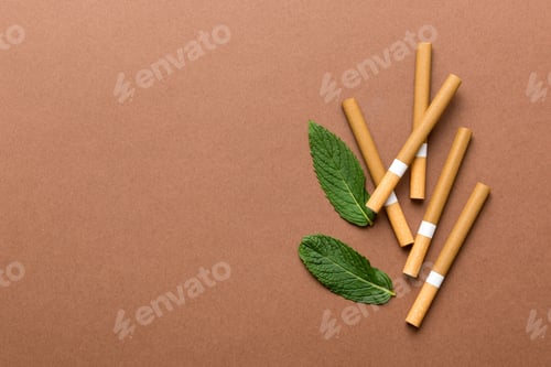 Preview: Menthol cigarettes and fresh mint leaves on colored background, Many cigarettes stacked